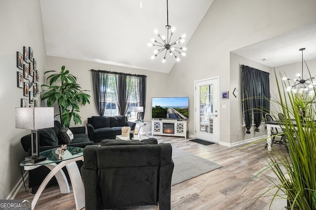 living room with an inviting chandelier, a healthy amount of sunlight, and hardwood / wood-style flooring