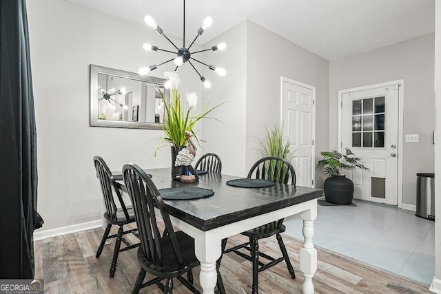 dining space featuring a textured ceiling, a notable chandelier, and wood-type flooring