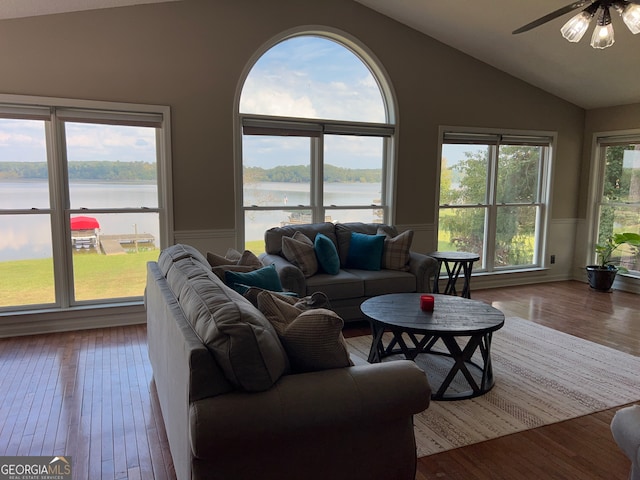 living room with a water view, vaulted ceiling, and hardwood / wood-style flooring