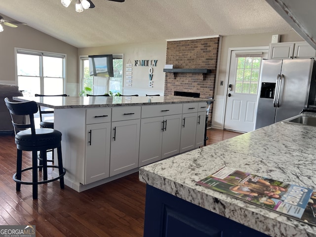 kitchen featuring white cabinetry, stainless steel fridge, and dark hardwood / wood-style floors