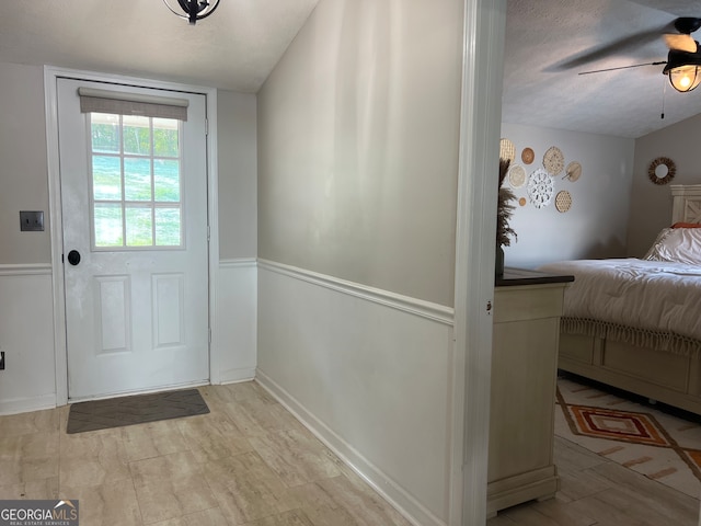 entryway featuring a textured ceiling and ceiling fan