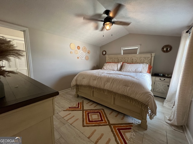 bedroom featuring a textured ceiling, vaulted ceiling, and ceiling fan