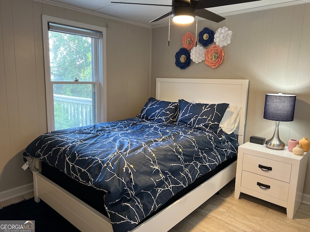 bedroom featuring ceiling fan, crown molding, and wood walls