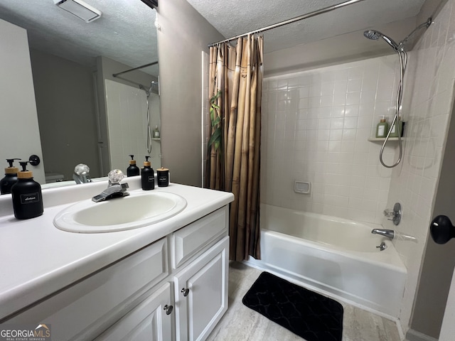 bathroom with a textured ceiling, vanity, shower / tub combo with curtain, and hardwood / wood-style floors