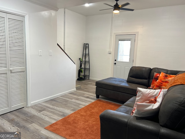 living room with light hardwood / wood-style flooring and ceiling fan