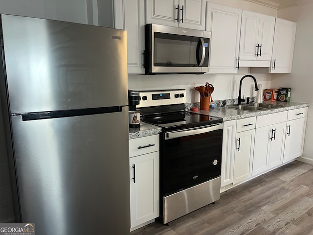 kitchen featuring white cabinetry, sink, hardwood / wood-style floors, and appliances with stainless steel finishes