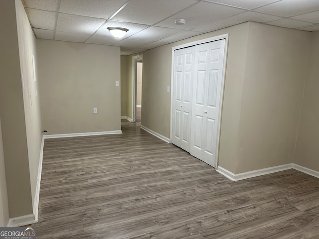 interior space featuring a paneled ceiling, hardwood / wood-style floors, and a closet