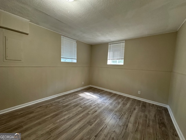 spare room featuring a textured ceiling and dark hardwood / wood-style flooring