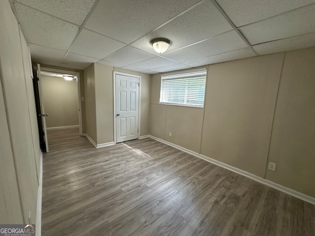 unfurnished bedroom featuring a paneled ceiling and hardwood / wood-style flooring