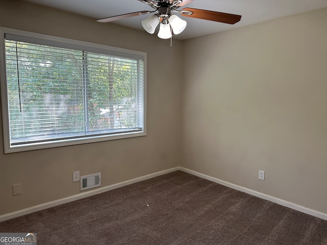 carpeted spare room featuring ceiling fan and a wealth of natural light