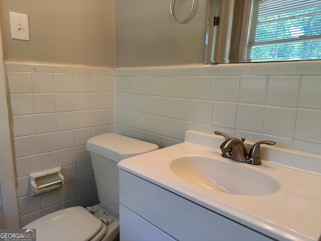 bathroom featuring tile walls, vanity, and toilet