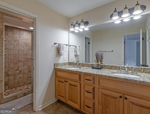 bathroom featuring tile patterned flooring, vanity, and tiled shower