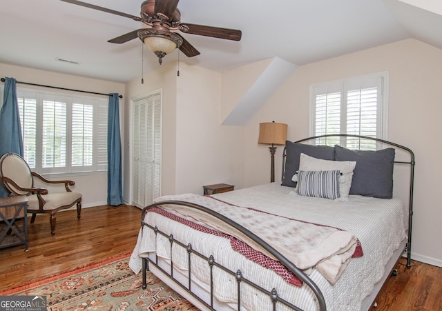 bedroom with wood-type flooring, a closet, multiple windows, and ceiling fan