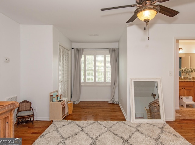 bedroom featuring light hardwood / wood-style floors, ensuite bath, and ceiling fan