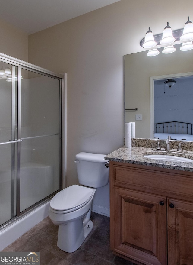 bathroom with vanity, tile patterned flooring, toilet, and an enclosed shower