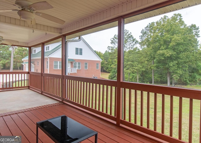 wooden terrace with ceiling fan and a lawn