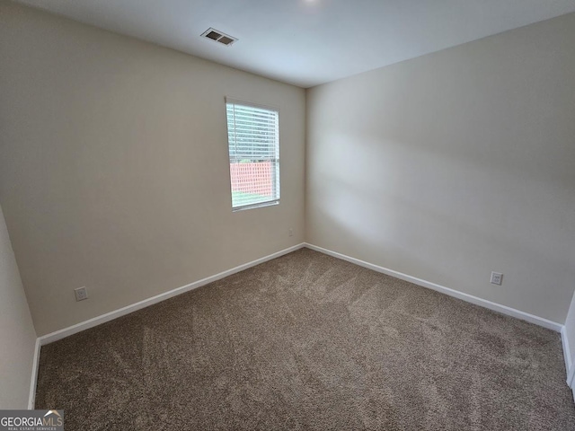 carpeted empty room featuring visible vents and baseboards