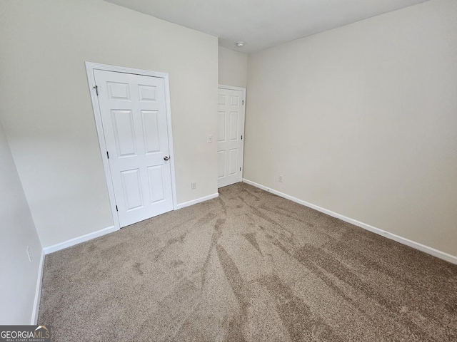 spare room featuring carpet flooring and baseboards