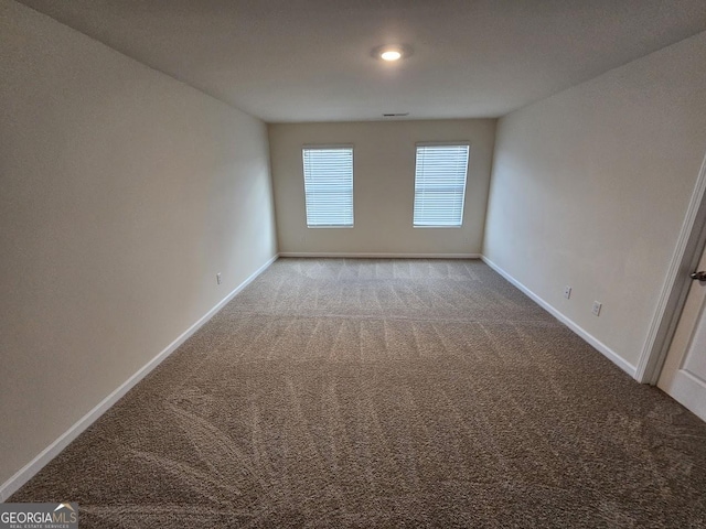 carpeted empty room featuring baseboards