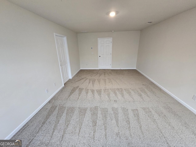 carpeted empty room featuring baseboards