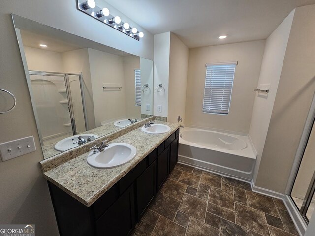 full bath featuring a shower stall, a garden tub, and a sink