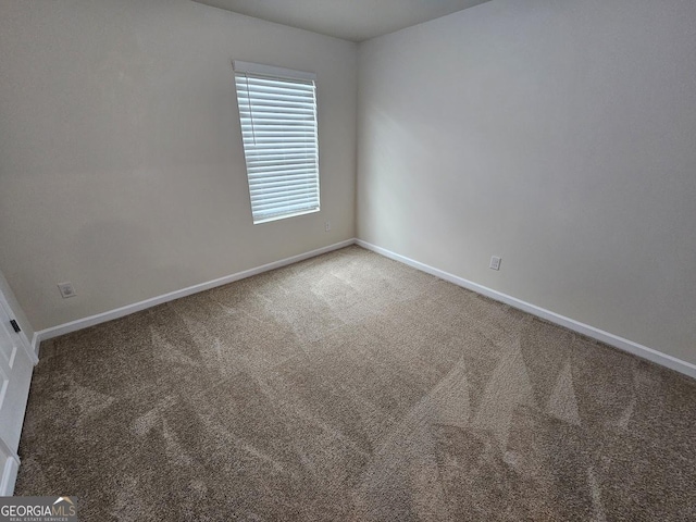 spare room with carpet flooring and baseboards