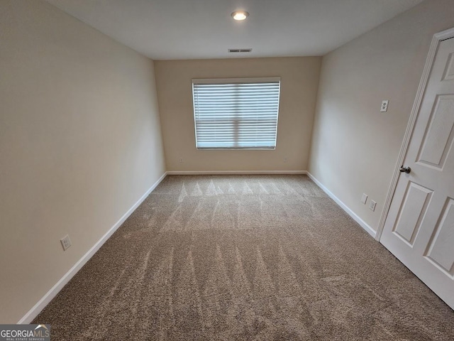 carpeted spare room with baseboards and visible vents