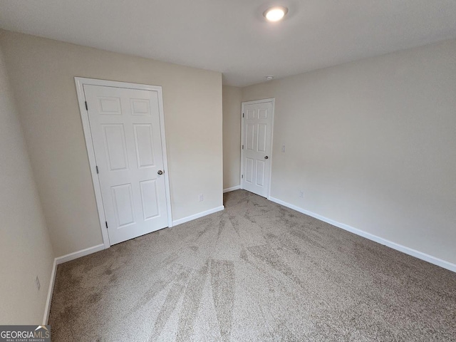 unfurnished bedroom featuring carpet flooring and baseboards