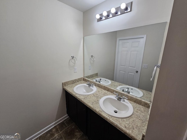 bathroom with double vanity, baseboards, and a sink