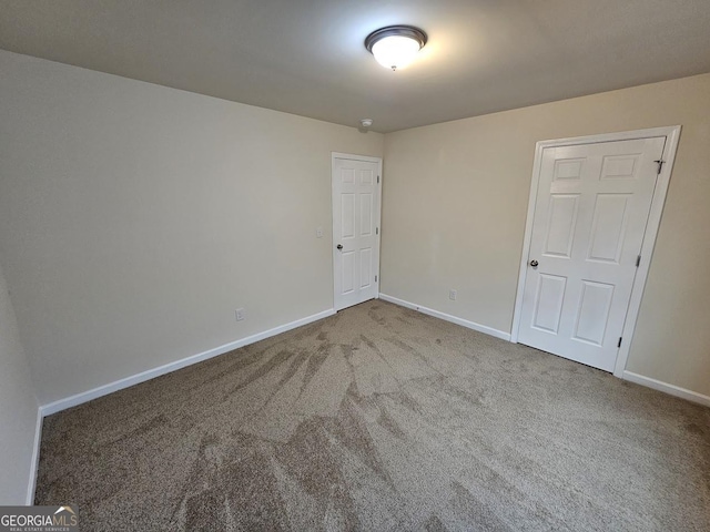 carpeted empty room with baseboards