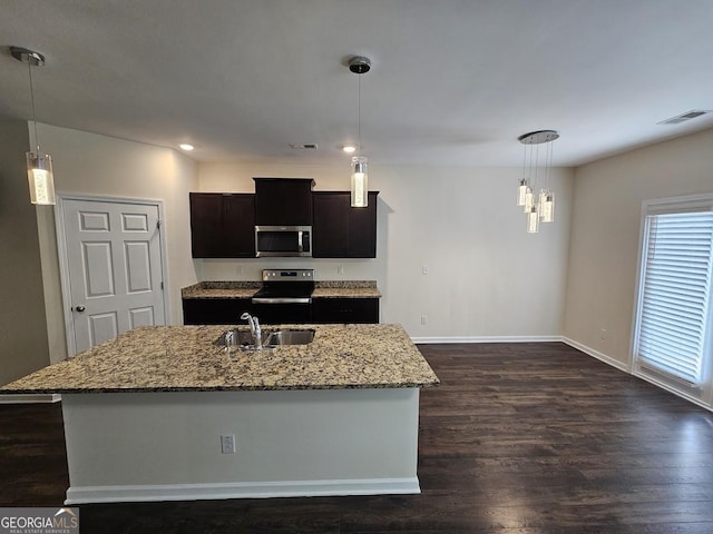 kitchen with visible vents, dark wood-type flooring, light stone counters, appliances with stainless steel finishes, and a sink