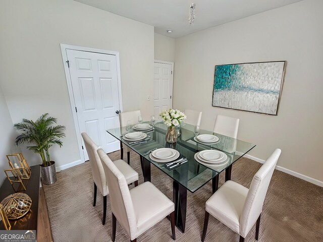 carpeted dining room with baseboards