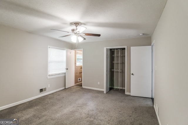 unfurnished bedroom with carpet, ceiling fan, and a textured ceiling