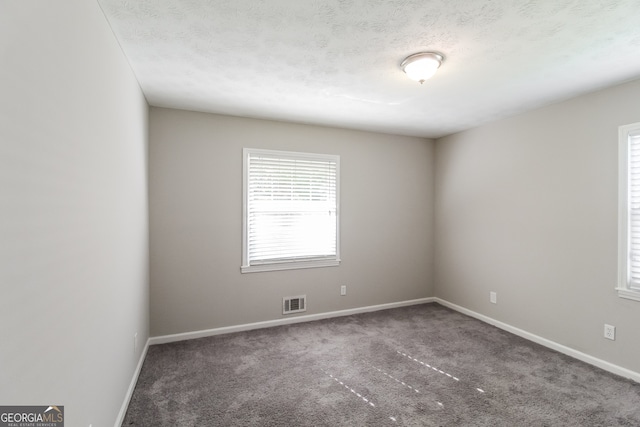 carpeted spare room with a textured ceiling