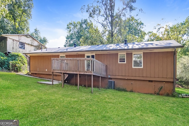 rear view of house with a wooden deck and a lawn