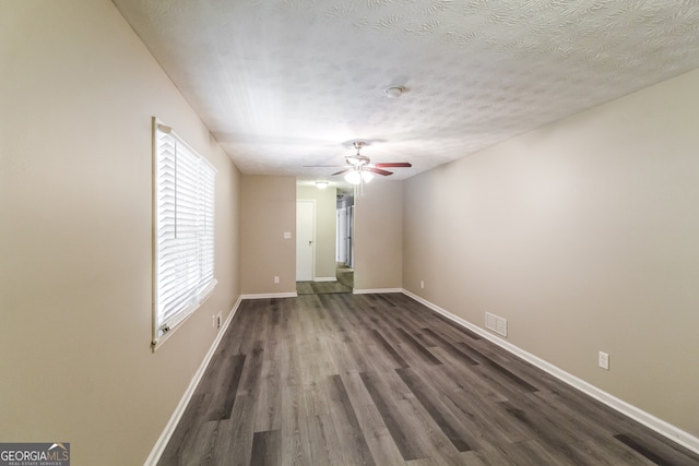 unfurnished room featuring ceiling fan, dark hardwood / wood-style floors, and a textured ceiling