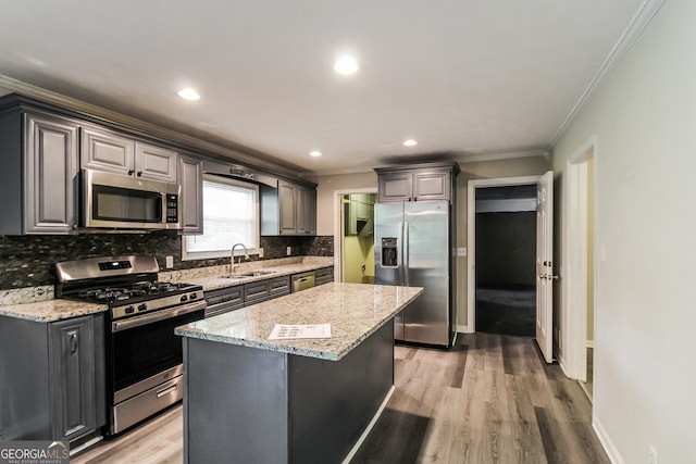 kitchen featuring a kitchen island, sink, light hardwood / wood-style flooring, and stainless steel appliances