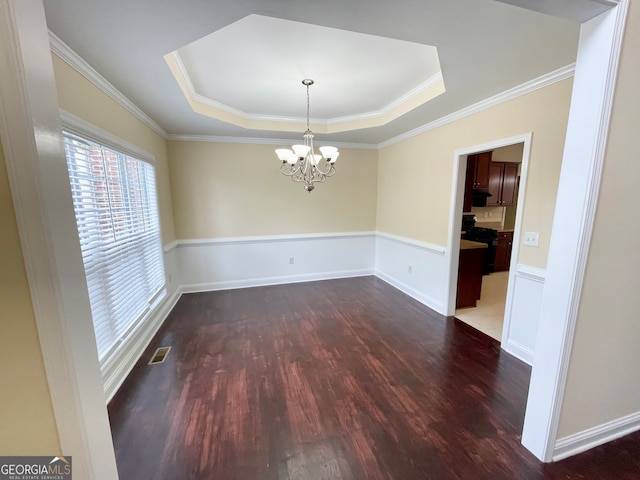 unfurnished dining area with an inviting chandelier, a raised ceiling, and dark hardwood / wood-style flooring