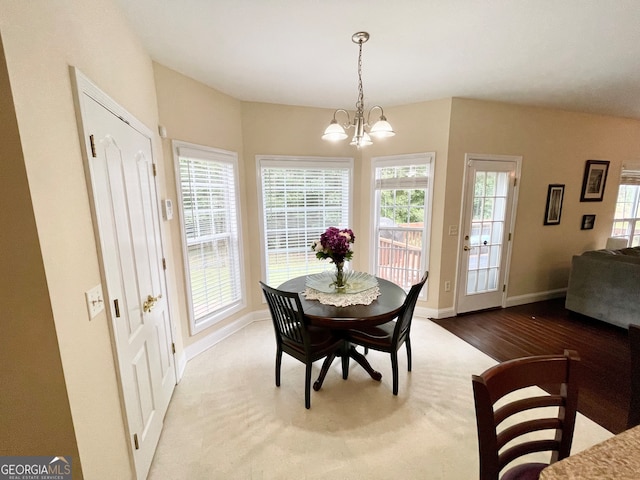 dining space featuring a healthy amount of sunlight, an inviting chandelier, and wood-type flooring