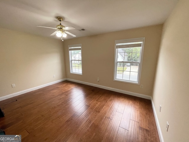 empty room with ceiling fan and dark hardwood / wood-style flooring