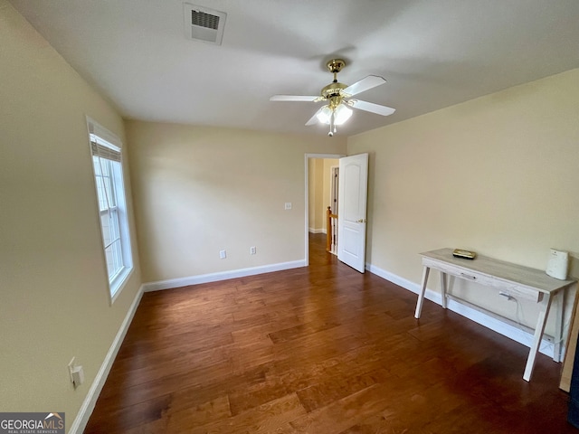 spare room featuring ceiling fan and dark wood-type flooring