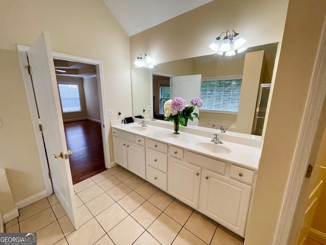 bathroom featuring vaulted ceiling, vanity, wood-type flooring, a washtub, and a chandelier