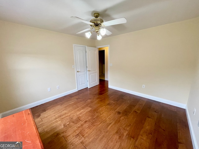 empty room featuring ceiling fan and dark wood-type flooring