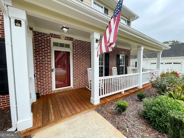 entrance to property with covered porch and a garage