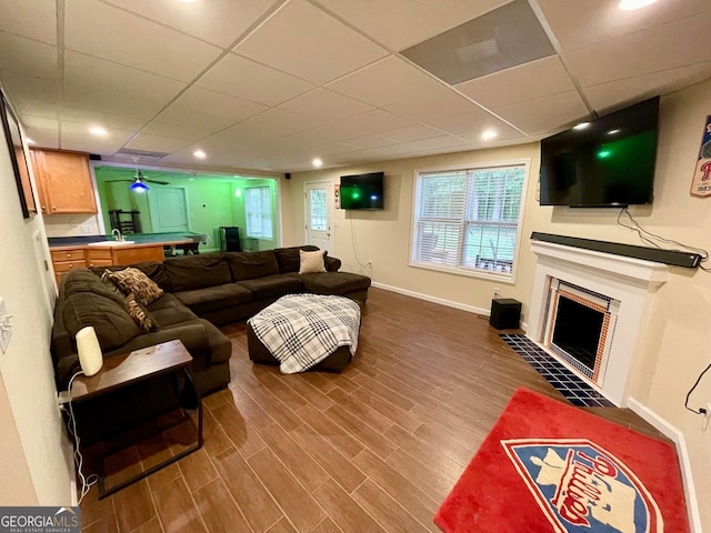 living room with hardwood / wood-style flooring and a paneled ceiling