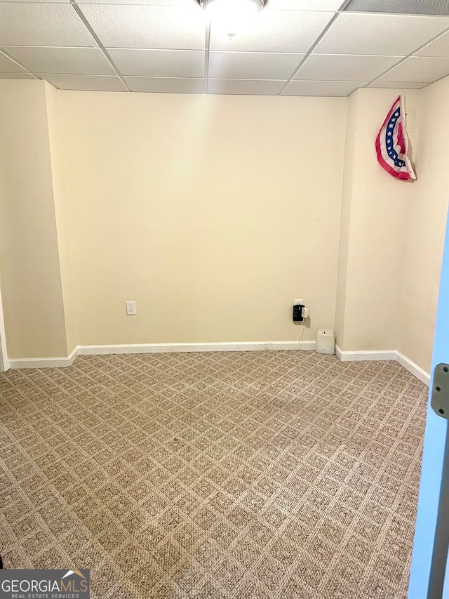 basement featuring a drop ceiling and carpet flooring