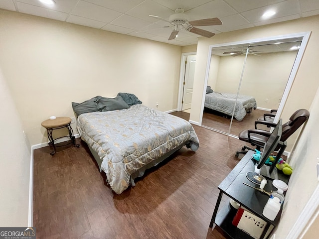 bedroom featuring dark wood-type flooring, ceiling fan, and a closet