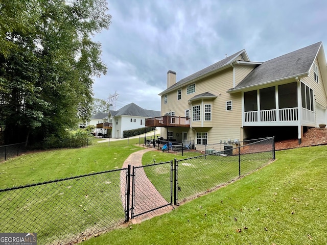 rear view of house featuring a sunroom and a yard