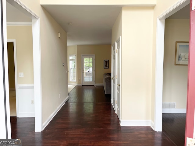 corridor with dark hardwood / wood-style floors and crown molding