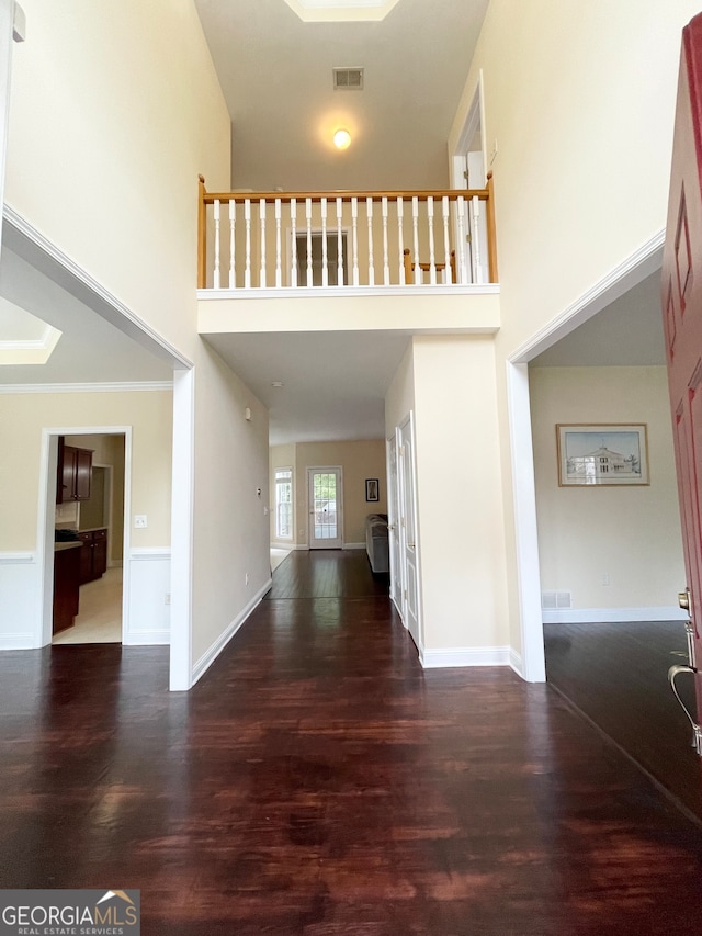 foyer entrance featuring a high ceiling and dark hardwood / wood-style floors